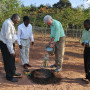 President Bill Clinton watering a sapling during a field visit